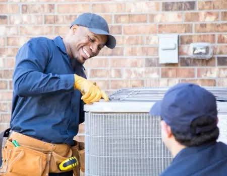 Two HVAC technicians inspecting an outdoor cooling system