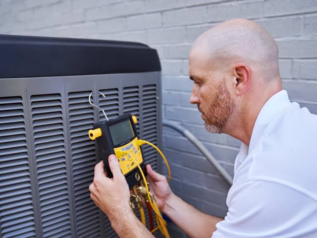 Technician using a diagnostic meter to check HVAC electrical components